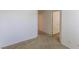 An empty bedroom with neutral carpet, white walls, and an open closet door at 9629 Toy Soldier St, Las Vegas, NV 89178