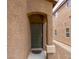 Stucco home featuring a neutral front door with an archway and low maintenance landscaping at 9629 Toy Soldier St, Las Vegas, NV 89178