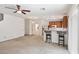 Open-concept living area with carpet, ceiling fan, bar seating and stainless appliances at 9629 Toy Soldier St, Las Vegas, NV 89178
