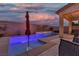 Backyard featuring a pool with a tanning ledge, an umbrella, string lights, and an outdoor seating area at 9917 Fletcher Peak Ave, Las Vegas, NV 89178