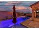 Backyard view of the pool and covered patio, with string lights and a seating area at 9917 Fletcher Peak Ave, Las Vegas, NV 89178