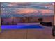 Stunning backyard pool area with ambient string lights, a waterfall feature, and a cozy seating area at 9917 Fletcher Peak Ave, Las Vegas, NV 89178