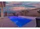 Backyard showcasing a luxurious pool with a waterfall feature, ambient string lights, and patio space at 9917 Fletcher Peak Ave, Las Vegas, NV 89178
