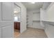 Walk-in closet featuring carpeted floors, shelving, and a view of the bathroom at 9917 Fletcher Peak Ave, Las Vegas, NV 89178