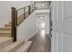 Bright entryway featuring wood floors, carpeted stairs, a modern railing, and an open floor plan at 9917 Fletcher Peak Ave, Las Vegas, NV 89178