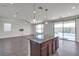 Open kitchen with a large island and stainless steel appliances, flowing to the living area and pool view at 9917 Fletcher Peak Ave, Las Vegas, NV 89178