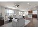 Sun-filled living room with modern decor and open to the updated kitchen with barstool seating at 9917 Fletcher Peak Ave, Las Vegas, NV 89178