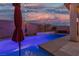 Backyard pool features a brick wall and string lights for ambient evening swims at 9917 Fletcher Peak Ave, Las Vegas, NV 89178