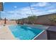 Sparkling pool surrounded by a brick wall, lush landscaping, and shaded seating areas at 9917 Fletcher Peak Ave, Las Vegas, NV 89178
