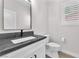 Bathroom featuring a modern vanity with a dark countertop, a window, and toilet at 10345 Howling Coyote Ave, Las Vegas, NV 89135