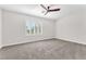 Spacious bedroom with large window, neutral carpet, and ceiling fan at 10345 Howling Coyote Ave, Las Vegas, NV 89135
