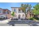 Two-story home with desert landscaping, a tile roof, and an inviting entryway at 10345 Howling Coyote Ave, Las Vegas, NV 89135
