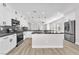 Modern kitchen featuring white cabinets, dark countertops, stainless appliances and wood-look floors at 10345 Howling Coyote Ave, Las Vegas, NV 89135