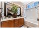 Bright bathroom with a double sink vanity, framed mirror and a bathtub/shower combo at 10701 Windrose Point Ave, Las Vegas, NV 89144