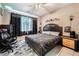 Stylish bedroom with a dark wood bed, desk, chair, and modern decor at 10701 Windrose Point Ave, Las Vegas, NV 89144