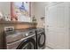 Functional laundry room with front load washer and dryer, shelving and a door to the exterior at 10701 Windrose Point Ave, Las Vegas, NV 89144