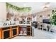 Open-concept living area showcasing kitchen elements, a desk space, and a comfortable lounge at 10701 Windrose Point Ave, Las Vegas, NV 89144