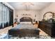 Comfortable main bedroom featuring a dark wooden bed frame, matching dressers and soft, neutral decor at 10701 Windrose Point Ave, Las Vegas, NV 89144