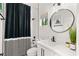 Modern bathroom features white vanity, round mirror, and black-and-white striped shower curtain at 10717 Beringer Dr, Las Vegas, NV 89144