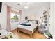 Bright bedroom featuring hardwood floors, a large window, a bed, a small bookcase and neutral colors at 10717 Beringer Dr, Las Vegas, NV 89144