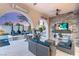 Luxurious outdoor living space with fireplace, TV, pool, and comfortable seating at 10717 Beringer Dr, Las Vegas, NV 89144