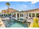 Backyard pool with integrated spa, covered patio, and lush landscaping at 10717 Beringer Dr, Las Vegas, NV 89144