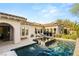 Backyard pool with waterfall feature, lush landscaping, and outdoor lounge seating at 10717 Beringer Dr, Las Vegas, NV 89144