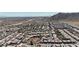 An aerial view shows houses lined up with open land and mountains afar at 10729 Marathon Bell Ln, Las Vegas, NV 89129
