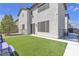 Expansive backyard featuring artificial grass, a well-maintained lawn, and outdoor seating area at 10729 Marathon Bell Ln, Las Vegas, NV 89129