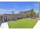 Fenced backyard featuring artificial grass, a bench, and ample space for outdoor activities at 10729 Marathon Bell Ln, Las Vegas, NV 89129