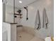 Tiled shower with sleek fixtures, built in shelf and bench, accompanied by neutral toned towels at 10729 Marathon Bell Ln, Las Vegas, NV 89129