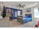Charming bedroom with blue accent wall, ceiling fan, a gray bed, and playful decor at 10729 Marathon Bell Ln, Las Vegas, NV 89129