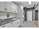 Well-organized laundry room with stacked washer and dryer, cabinetry, and counter space at 10729 Marathon Bell Ln, Las Vegas, NV 89129