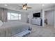 Generous primary bedroom with carpeted floor, ceiling fan, large windows, tv and relaxing decor at 10729 Marathon Bell Ln, Las Vegas, NV 89129