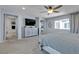 Large primary bedroom with carpeted floor, ceiling fan, large windows, tv and ensuite bathroom access at 10729 Marathon Bell Ln, Las Vegas, NV 89129