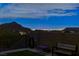 Tranquil backyard with a view of the mountains and city lights in the distance at twilight at 10729 Marathon Bell Ln, Las Vegas, NV 89129