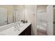 Clean bathroom features a dark vanity, white countertop, and shower with glass doors at 11707 Longworth Rd, Las Vegas, NV 89135