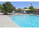 Community pool with clear blue water, lounge chairs, and nearby shaded seating, perfect for relaxation at 11707 Longworth Rd, Las Vegas, NV 89135