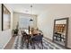 Chic dining room features a stylish wood table, gray chairs, decorative mirror, and modern rug at 11707 Longworth Rd, Las Vegas, NV 89135