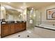 Bathroom boasts dual vanity, walk-in shower, soaking tub and a decorative mirror at 125 E Harmon Ave # 717, Las Vegas, NV 89109