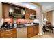 Charming kitchenette features sleek black countertops, wood cabinets, stainless steel microwave and minifridge, and TV at 125 E Harmon Ave # 717, Las Vegas, NV 89109