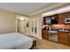 Bright primary bedroom showcasing white bedding, wood cabinets and kitchenette with stainless steel appliances at 125 E Harmon Ave # 717, Las Vegas, NV 89109