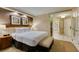 Bright primary bedroom featuring a king bed, sitting area, and ensuite bath behind glass doors at 125 E Harmon Ave # 717, Las Vegas, NV 89109