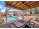 Relaxing backyard with a pool, covered patio, and comfortable lounge chairs at 1320 Wengert Ave, Las Vegas, NV 89104