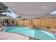 A backyard swimming pool beneath a shade, is accented with well-placed landscaping near a wooden fence at 1320 Wengert Ave, Las Vegas, NV 89104
