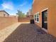 Low maintenance backyard featuring gravel landscaping, brick walls, and a rear entry door at 148 Campbelltown Ave, Henderson, NV 89015