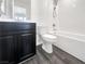 A modern bathroom with a dark vanity, white toilet, and tiled shower/tub combo at 148 Campbelltown Ave, Henderson, NV 89015