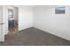 A clean, carpeted bedroom with neutral walls and a bright window with a view of the bathroom at 148 Campbelltown Ave, Henderson, NV 89015