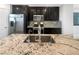 A gourmet kitchen with granite countertops, stainless steel appliances, and dark wood cabinetry at 148 Campbelltown Ave, Henderson, NV 89015