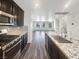 Modern kitchen with stainless steel appliances, granite countertops, and dark wood cabinets at 148 Campbelltown Ave, Henderson, NV 89015
